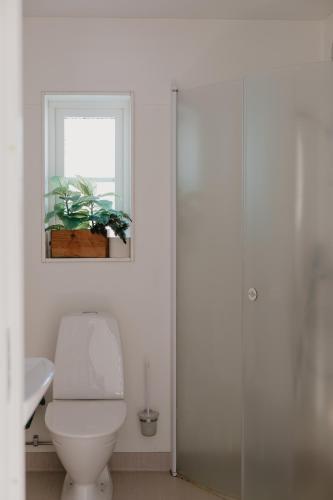 a white bathroom with a toilet and a window at Mösseberg Camping in Falköping