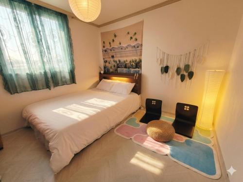 a small bedroom with a bed and a large window at 전주한옥마을 스테이네슬 in Jeonju