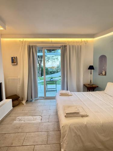 a bedroom with a bed and a sliding glass door at Corfu Olive Village with Swimming Pool Castello Di Vista in Análipsis