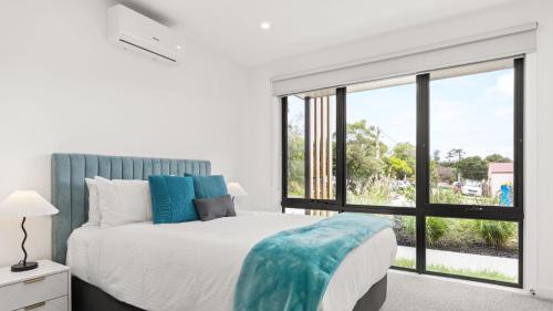 a bedroom with a large bed and a large window at Fleetwood Atelier in Frankston South