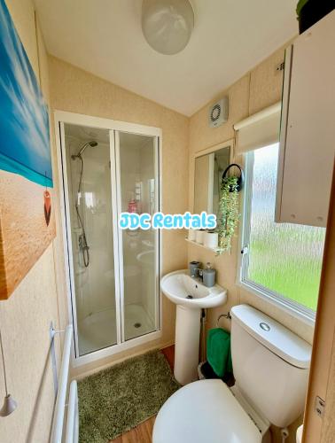 a bathroom with a shower and a toilet and a sink at Palins - KC19 in Kinmel Bay