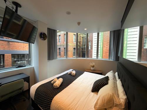 a bedroom with a bed with two stuffed animals on it at Spice Serviced Apartments in Sydney