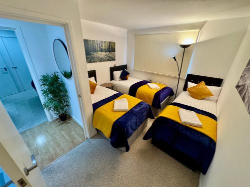 a hotel room with two beds and a mirror at 2 Bed, 2 Bath, Ground Floor Whole Apartment with Parking, Near Central London & Stratford, Close to Station, Zone 2 in London