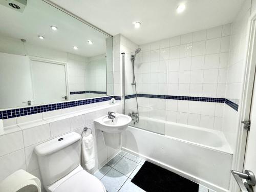 a bathroom with a toilet and a sink and a bath tub at 2 Bed, 2 Bath, Ground Floor Whole Apartment with Parking, Near Central London & Stratford, Close to Station, Zone 2 in London