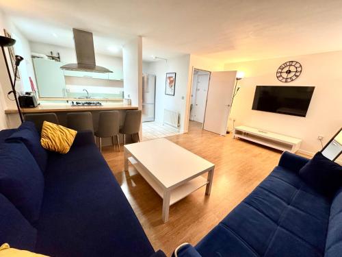 a living room with a blue couch and a table at 2 Bed, 2 Bath, Ground Floor Whole Apartment with Parking, Near Central London & Stratford, Close to Station, Zone 2 in London