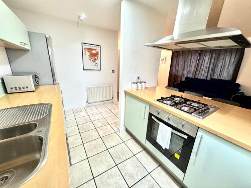 a kitchen with a sink and a stove top oven at 2 Bed, 2 Bath, Ground Floor Whole Apartment with Parking, Near Central London & Stratford, Close to Station, Zone 2 in London