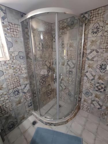 a shower with a glass door in a bathroom at Ktima Kariofillis in Révmata