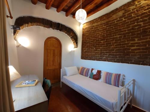 a living room with a couch and a brick wall at Ktima Kariofillis in Révmata