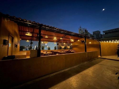 a rooftop patio with a dining area at night at Hotel Liora in Rajkot