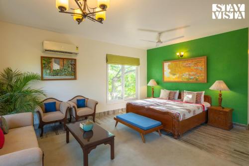 a bedroom with a bed and a green wall at StayVista at The Hideout Farms with Lawn and private Pool in Kurukshetra