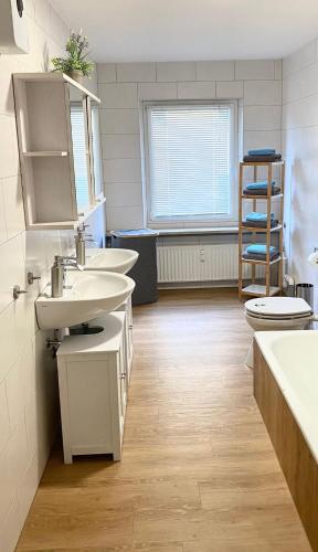 a bathroom with two sinks and a toilet at Ferienwohnung Freedom 2 Sky Terrasse High End in Northeim