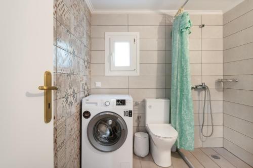a bathroom with a washing machine and a toilet at Angelina's Cute House in Neapoli Voion
