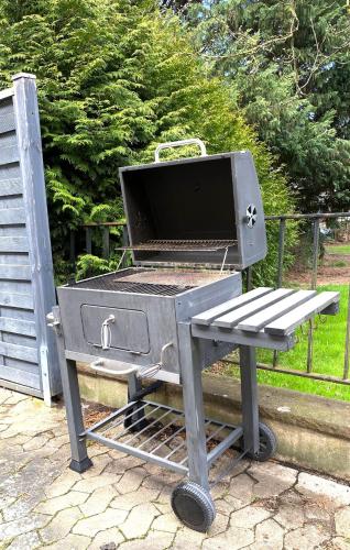 a barbecue grill with a bench next to a fence at Ferienwohnung Freedom 1 Sky Terrasse High End in Northeim
