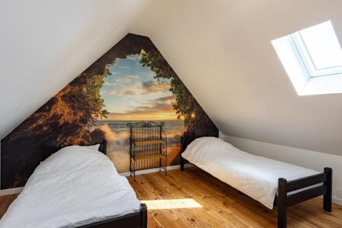 two beds in a attic bedroom with a wall mural at Maison Vintage de Kerlipot in Ploubezre