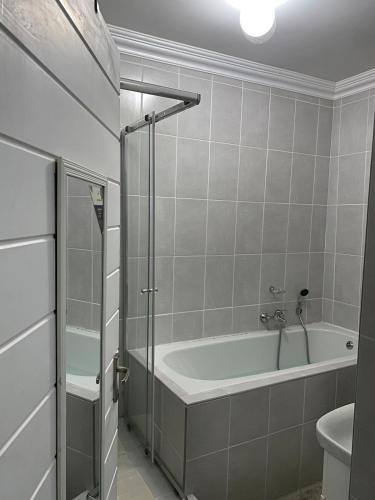 a bathroom with a bath tub and a toilet at Pule's Home & Studio Apartments in Maseru