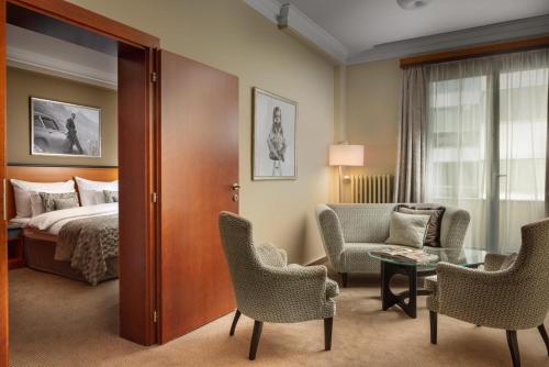 ein Hotelzimmer mit Bett, Tisch und Stühlen in der Unterkunft Jalta Boutique Hotel in Prag