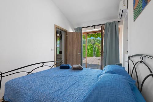 a bedroom with a bed with a blue comforter at Casa Kim - Capoliveri in Capoliveri