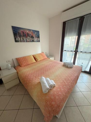 a bedroom with a large bed with towels on it at la iaia's home in Rozzano