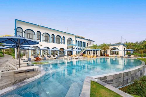 a large swimming pool in front of a building at Aqua Vista Hoi An Beachfront Villas in Hoi An