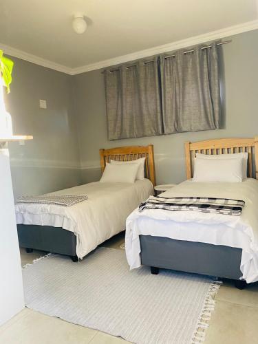 two beds sitting next to each other in a bedroom at Pule's Home & Studio Apartments in Maseru