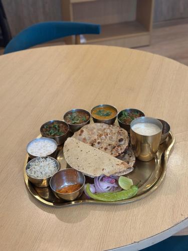 a tray with a plate of food on a table at Hotel KG Estate in Jaipur
