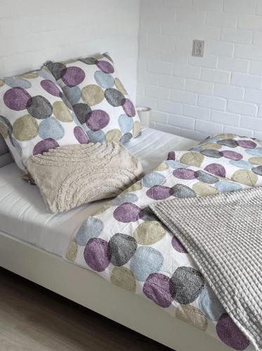 a bed with a comforter and pillows on it at Buitenplaats Herkingen 25-A in Herkingen