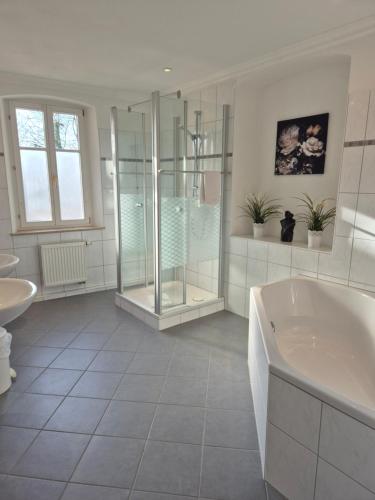 a bathroom with a tub and a shower and a sink at Boutiquehotel Goldene Rose - self-check-in in Rothenburg ob der Tauber