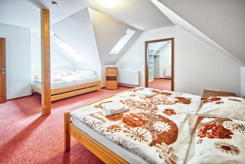 a attic bedroom with a bed and a mirror at U Jeřába - komplex B in Horní Věstonice