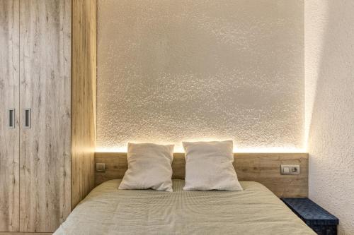 a bed with two pillows on top of it at Amarres con Piscina in L'Escala