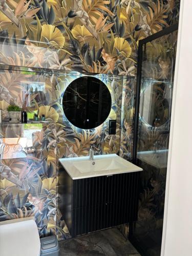 a bathroom with a sink and a mirror at Apartamenty przy Muzeum in Brzeziny