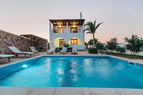 a swimming pool in front of a villa at Deep Blue Villa in Lachania