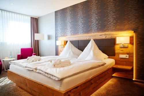 a bedroom with a large bed with towels on it at Hotel Tannhof in Feldberg