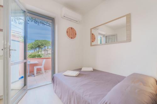 a bedroom with a bed and a mirror and a balcony at Marina Vip Anna in Procchio