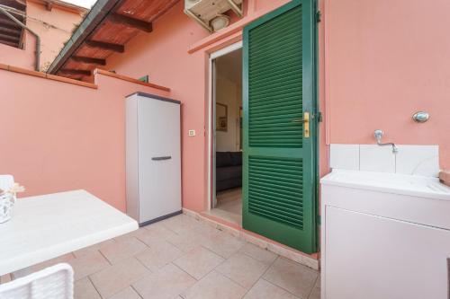 a bathroom with a green door and a sink at Marina Vip Anna in Procchio