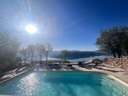a swimming pool with the sun in the sky at Domaine de la Ferme Para Lou in Sainte-Croix-de-Verdon