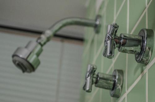 a pair of faucets on a bathroom wall at Mont Blanc Apart Hotel - Duque de Caxias in Duque de Caxias