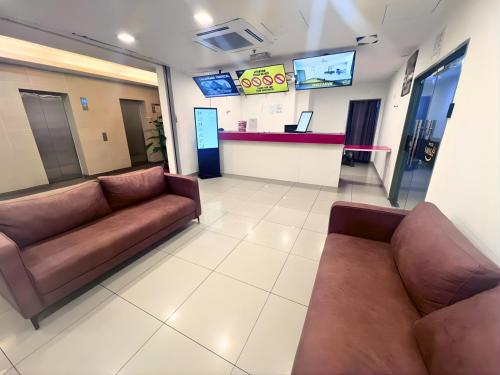 a waiting room with brown leather couches in a hospital at Smile Hotel Damansara Tropical in Petaling Jaya