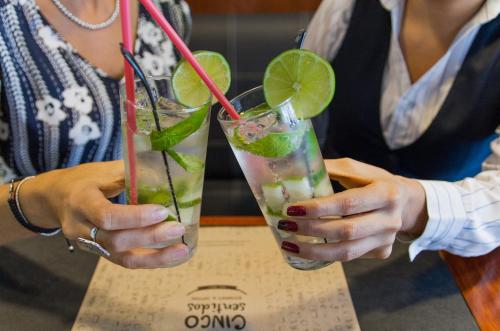 a woman holding two drinks in her hands at Hotel Finlandia in Quito