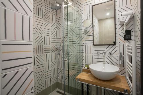 a bathroom with a sink and a glass shower at Solun's Riverside Rooms in Skopje