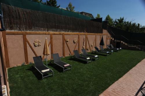 a row of chairs and umbrellas on the grass at El Rincón de Monasterio in Monasterio