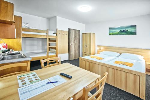 a room with two beds and a table and a kitchen at U Jeřába - komplex A in Horní Věstonice