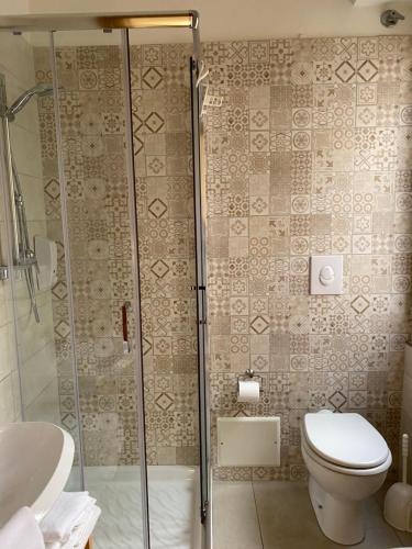 a bathroom with a toilet and a glass shower at B&B Vento di Terra in Gaeta