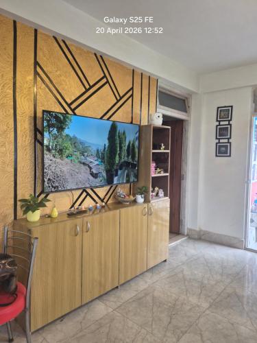 a living room with a flat screen tv on a wall at Happy Farmstead in Darjeeling