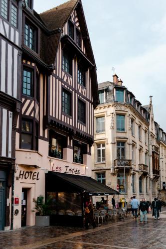 a group of buildings on a street with people walking at Les Initiés in Rouen