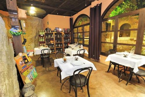 um restaurante com mesas e cadeiras brancas num quarto em Cal Marroso em Montsonis