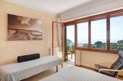 a bedroom with a bed and a chair and a balcony at Casa Braun in Bonassola