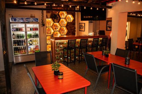 a restaurant with red tables and chairs and a refrigerator at Bougainvilla Kolwezi Guesthouse in Kolwezi