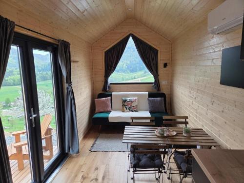 a room with a couch and a table and a window at Lahod Tiny House by Tiny Away in Žalec