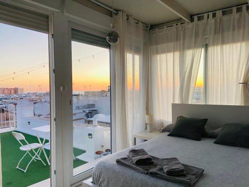 a bedroom with a bed and a view of a city at Ático Cádiz 360 in Cádiz