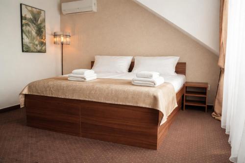 a bedroom with a bed with towels on it at Penzión Hoffer in Nitra